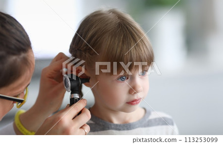 Otorhinolaryngologist examines little girl's ear with otoscope in clinic Otorhinolaryngologist examines little girl's ear with otoscope in clinic 113253099