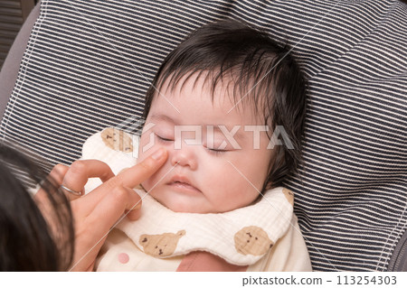[Wipping the tears of a sitting baby] 113254303