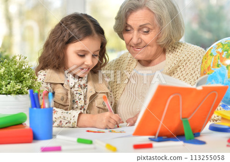 Happy Grandmother with granddaughter drawing together Happy Grandmother with granddaughter drawing together 113255058