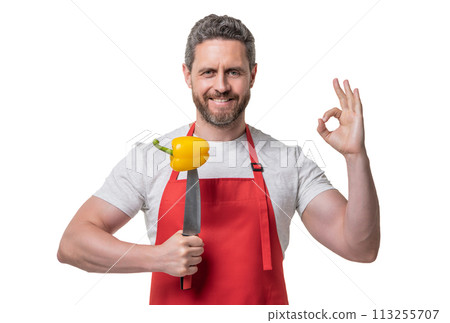 man in apron with sweet pepper vegetable and knife isolated on white. ok man in apron with sweet pepper vegetable and knife isolated on white. ok 113255707