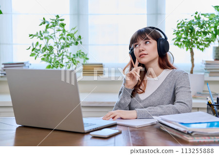 Girl teenage student in headphones having video chat online on computer 113255888