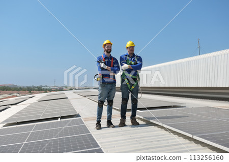 Engineers install solar cells on the roof of factory Engineers install solar cells on the roof of factory 113256160