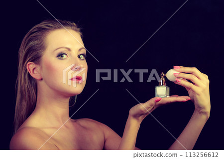 Beautiful woman with holding and applying perfume 113256612