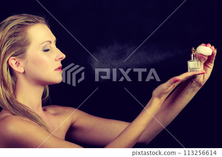 Beautiful woman with holding and applying perfume Beautiful woman with holding and applying perfume 113256614