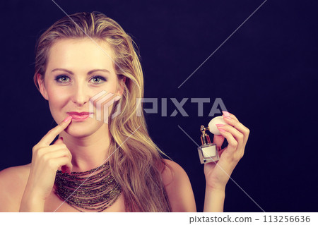 Beautiful woman with necklace holding perfume Beautiful woman with necklace holding perfume 113256636