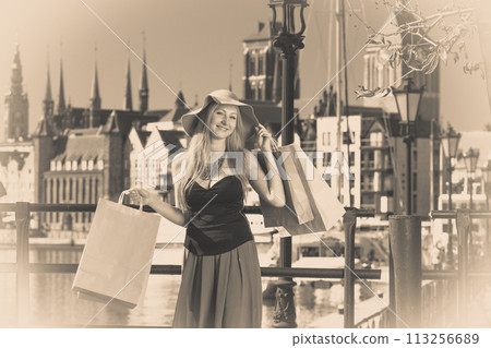 Fashionable woman walking with shopping bags 113256689