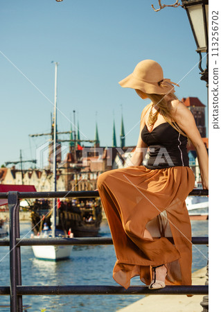 Sitting woman wearing big sun hat and elegant dress Sitting woman wearing big sun hat and elegant dress 113256702