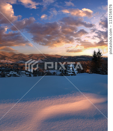 Alpine village outskirts in last evening sunset sun light. Winter snowy hills and fir trees. High resolution stitch image with great depth of field. Alpine village outskirts in last evening sunset sun light. Winter snowy hills and fir trees. High resolution stitch image with great depth of field. 113256976