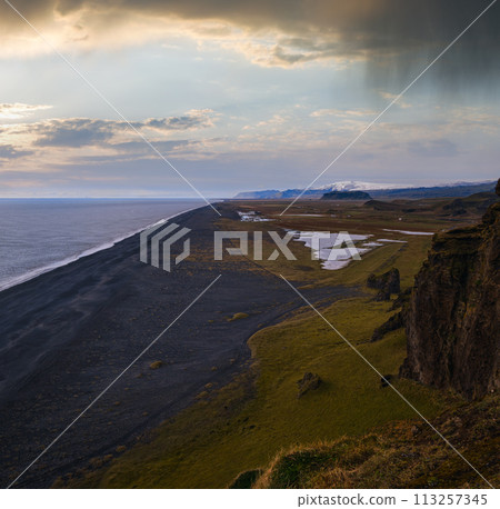Picturesque autumn evening view to endless ocean black volcanic sand beach from Dyrholaey Cape Viewpoint, Vik, South Iceland. Picturesque autumn evening view to endless ocean black volcanic sand beach from Dyrholaey Cape Viewpoint, Vik, South Iceland. 113257345