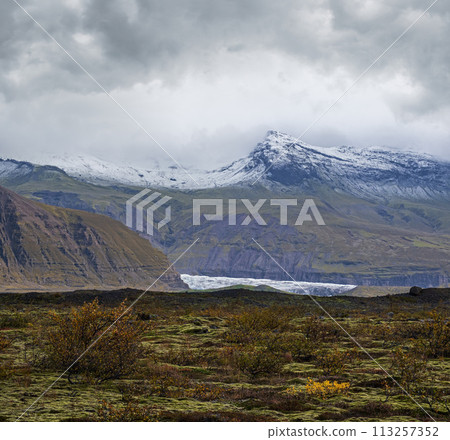 Iceland autumn tundra landscape near Haoldukvisl glacier, Iceland. Glacier tongue slides from the Vatnajokull icecap or Vatna Glacier near subglacial Esjufjoll volcano. Not far from Iceland Ring Road. Iceland autumn tundra landscape near Haoldukvisl glacier, Iceland. Glacier tongue slides from the Vatnajokull icecap or Vatna Glacier near subglacial Esjufjoll volcano. Not far from Iceland Ring Road. 113257352