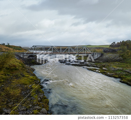 Hrutey island public park near Blonduos town, North-West of Iceland. View during auto trip by Ring Road. Spectacular Icelandic landscape with scenic autumn nature and Blanda river with cataracts. 113257358