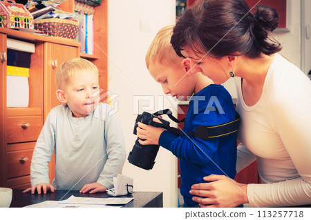 Kid playing with big professional digital camera 113257718