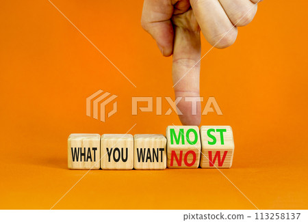 What you want now or most symbol. Concept word What you want now or most on cubes. Beautiful orange background. Psychologist hand. Psychological what you want now or most concept. Copy space. 113258137