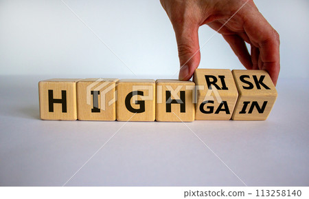 Cube form the expression 'high risk, high gain'. Male hand. Beautiful white background. Business concept, copy space. 113258140