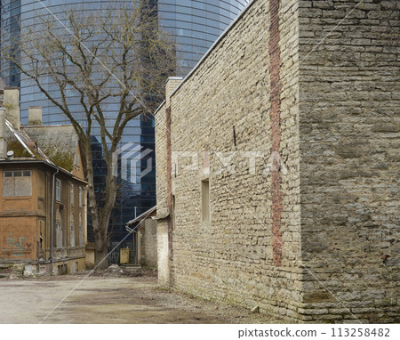 old courtyard, tree and modern office building in Tallinn, Estonia old courtyard, tree and modern office building in Tallinn, Estonia 113258482
