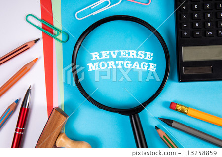 Reverse Mortgage. Magnifying glass and stationery on the office table 113258859