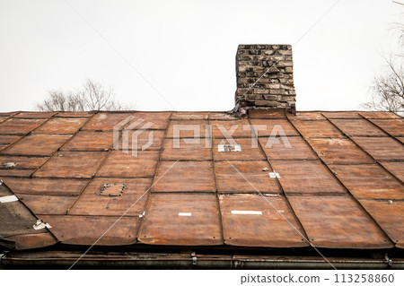 Old rusty metal roof with patches. Repair and renovation 113258860