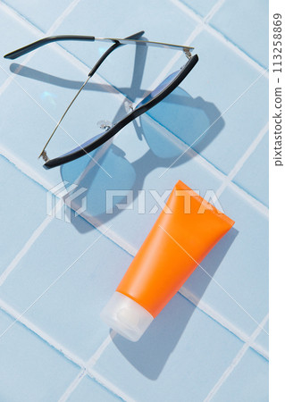 Sunscreen lotion on blue background. Care products summer beach accessories Sunscreen lotion on blue background. Care products summer beach accessories 113258869
