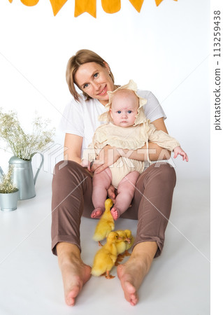 mother and her daughter playing with a small duckling 113259438