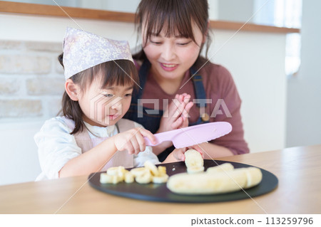 Girl helping her mother cook 113259796