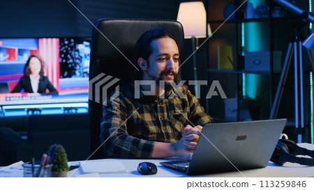 Smiling man relaxing in cozy living room by watching funny internet clips on laptop. Carefree caucasian person enjoying leisure time in RGB lit apartment, looking at online videos, camera A Smiling man relaxing in cozy living room by watching funny internet clips on laptop. Carefree caucasian person enjoying leisure time in RGB lit apartment, looking at online videos, camera A 113259846