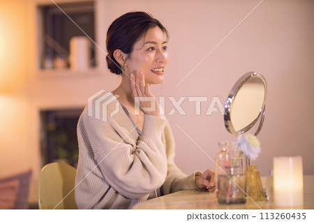 Middle-aged woman doing night skin care Middle-aged woman doing night skin care 113260435
