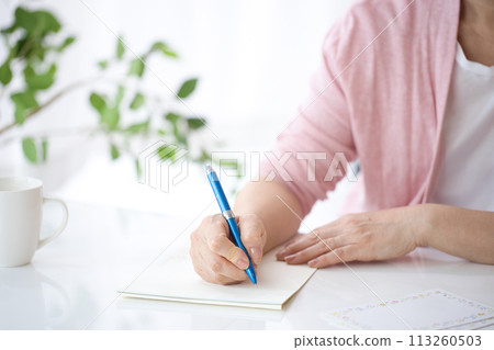 Hand of a middle-aged woman writing a letter 113260503