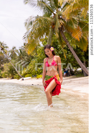 Beachwear Bliss: Young Woman in Colorful Bikini and Sarong by the Sea. his image is completely unretouched and unedited and model is with no makeup. Original Raw Image Beachwear Bliss: Young Woman in Colorful Bikini and Sarong by the Sea. his image is completely unretouched and unedited and model is with no makeup. Original Raw Image 113260536