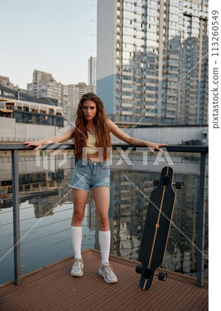 Young teenage woman enjoying time for skateboarding through city street Young teenage woman enjoying time for skateboarding through city street 113260549