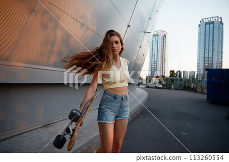 Charming young woman with skateboard 113260554