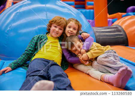 Cute little kids of different age playing on inflatable bounce house 113260580
