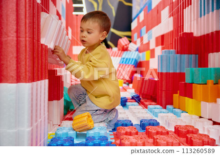Boy child playing with huge building blocks in entertainment center Boy child playing with huge building blocks in entertainment center 113260589