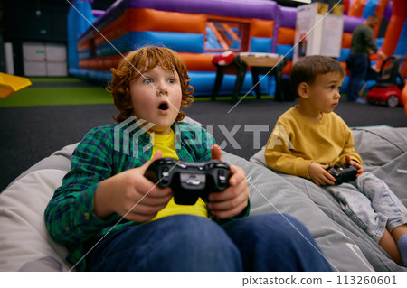 Portrait of excited boy with surprise and joy on face playing video game 113260601