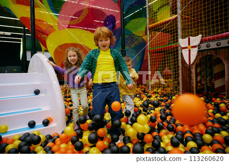 Amazed carefree preschool children playing together on indoor playground 113260620
