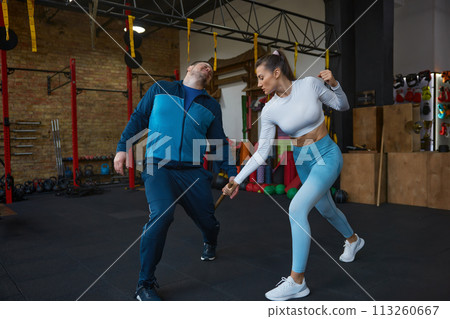 Young woman fighting with stick practicing Bo-Jutsu or Kung Fu with trainer 113260667