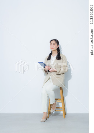 Smiling businesswoman holding a tablet 113261062
