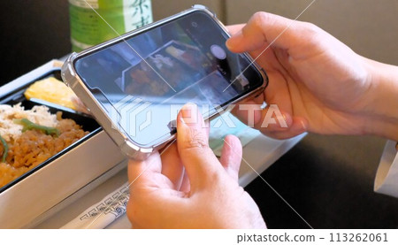 A woman taking a photo of an ekiben on the Tokaido Shinkansen A woman taking a photo of an ekiben on the Tokaido Shinkansen 113262061