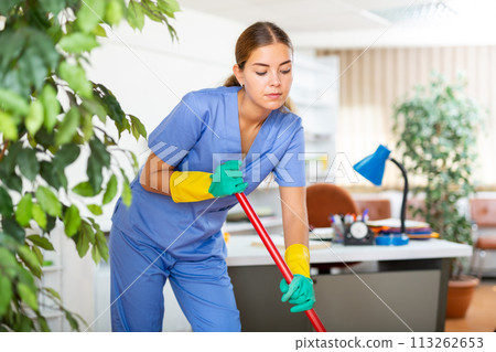 Female worker of office cleaning service wiping floors with mop Female worker of office cleaning service wiping floors with mop 113262653