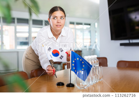 Female secretary places flags of the European Union and South Korea flag on table before the negotiations of top political figures Female secretary places flags of the European Union and South Korea flag on table before the negotiations of top political figures 113262716