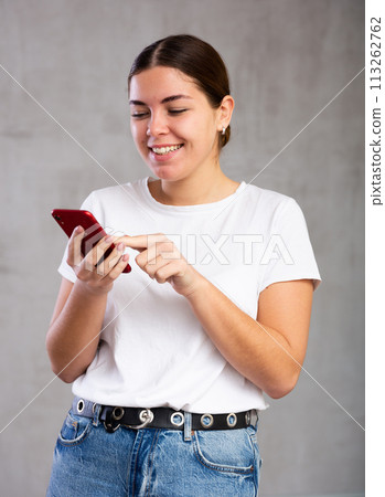 Cheerful young woman looking gladly at mobile 113262762