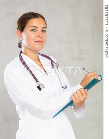 Young woman in medical uniform making notes 113263182