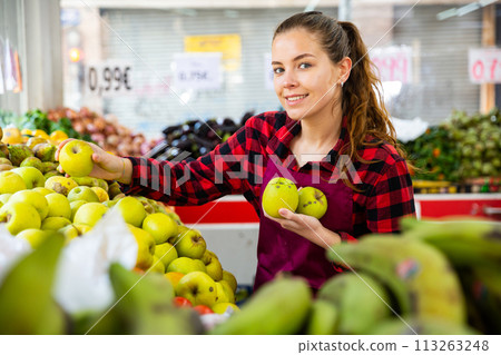 Female seller lay out ripe apples on the counter 113263248