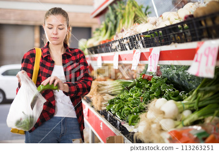 Portrait of cheerful female customer buying fresh pepper Portrait of cheerful female customer buying fresh pepper 113263251