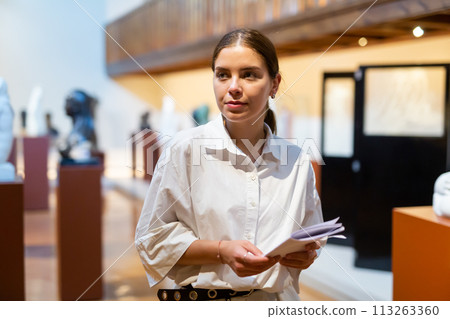 Woman looking at stone architectural elements in historical museum Woman looking at stone architectural elements in historical museum 113263360