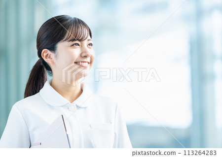 一名女醫務人員走過走道。 一名女醫務人員走過走道。 113264283