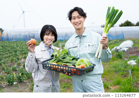 Young male and female farmers holding crops 113264677