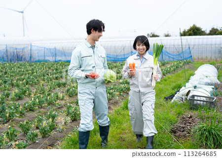 Young male and female farmers holding crops 113264685