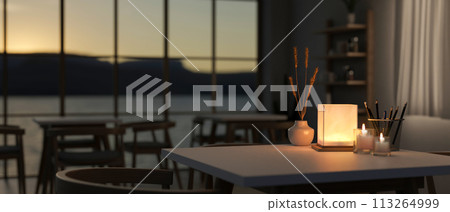 A table with a dim light from a table lamp in a contemporary romantic restaurant at night. 113264999