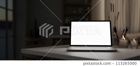 A white-screen laptop computer mockup on a table in a modern dark room. 113265000