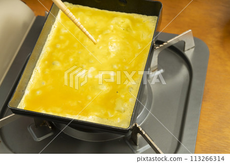 Tamagoyaki process: pouring in the eggs 113266314